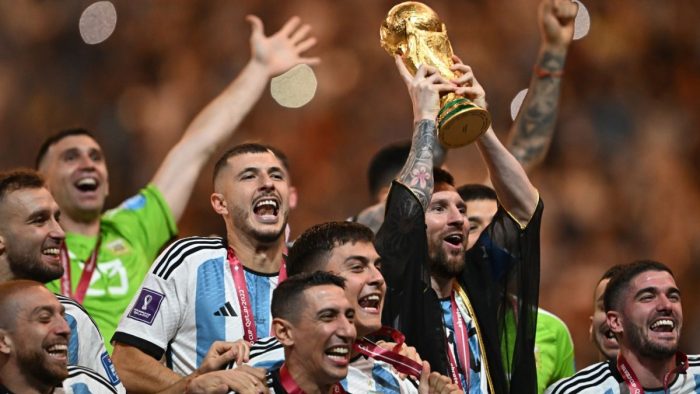 Argentina's captain and forward #10 Lionel Messi lifts the FIFA World Cup Trophy as he celebrates with teammates after winning the Qatar 2022 World Cup final football match between Argentina and France at Lusail Stadium in Lusail, north of Doha on December 18, 2022. (Photo by Paul ELLIS / AFP)