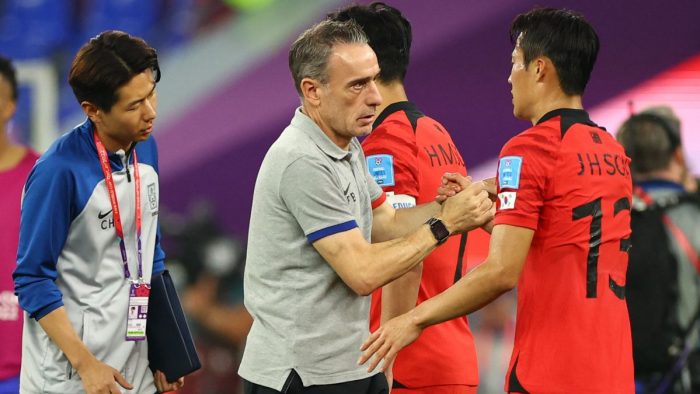 Soccer Football - FIFA World Cup Qatar 2022 - Round of 16 - Brazil v South Korea - Stadium 974, Doha, Qatar - December 5, 2022 South Korea coach Paulo Bento shakes hands with Son Jun-ho as he looks dejected after being eliminated from the World Cup REUTERS/Kim Hong-Ji