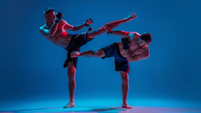 mma-two-professional-fighters-punching-boxing-isolated-blue-wall-neon